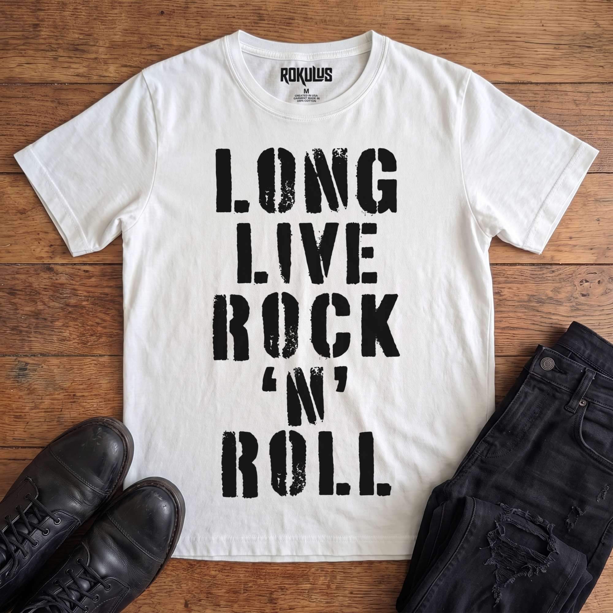 White Rokulus Long Live Rock 'n' Roll vintage graphic tee laid flat on wood with black boots and jeans, front print showing "Long Live Rock 'n' Roll" stacked vertically in heavy distressed black stencil lettering
