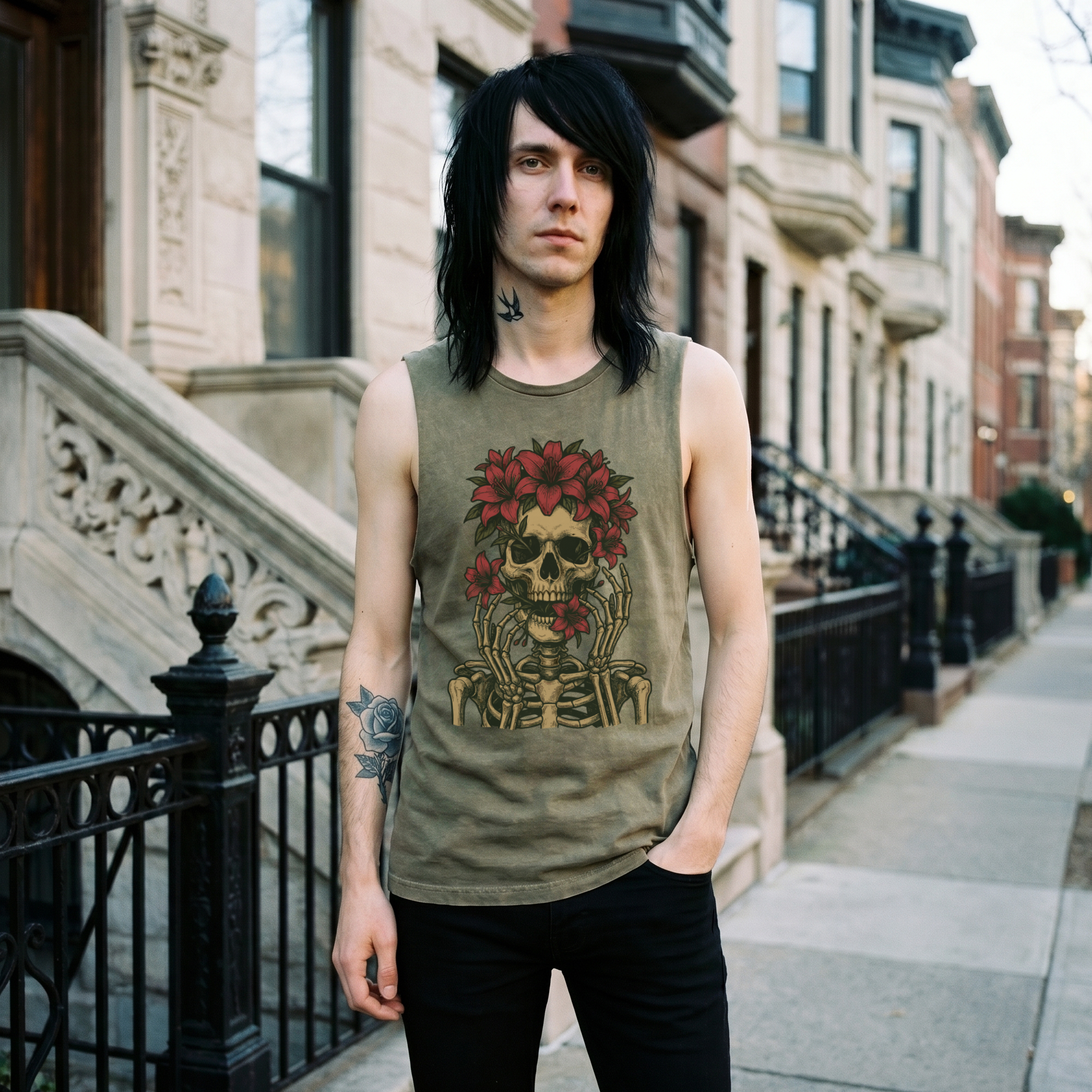 Man with long black hair wearing a moss green Floral Skull tank top, front view, standing on a brownstone-lined street